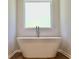 Modern bathroom featuring a freestanding white soaking tub with brushed-nickel fixtures under a frosted glass window at 679 Egrets Landing Lot 57, Covington, GA 30014