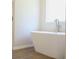 Modern bathroom featuring a white freestanding tub and wood-look tile floors at 679 Egrets Landing Lot 57, Covington, GA 30014