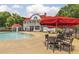 Resort-style outdoor pool area with lounge chairs, red umbrellas, clubhouse, tables, and landscaped surroundings at 679 Egrets Landing Lot 57, Covington, GA 30014