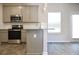 Modern kitchen featuring stainless steel appliances, sleek cabinets, and wood-look flooring at 679 Egrets Landing Lot 57, Covington, GA 30014