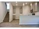 Open-concept kitchen and stairs featuring modern appliances, gray cabinets, and wood-look flooring at 679 Egrets Landing Lot 57, Covington, GA 30014