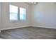 Bright living room with wood-look flooring, neutral walls, and large windows allowing ample natural light at 679 Egrets Landing Lot 57, Covington, GA 30014