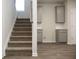 Carpeted stairs next to the modern kitchen, with gray cabinets and stylish backsplash at 679 Egrets Landing Lot 57, Covington, GA 30014