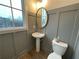 Elegant powder room with pedestal sink, wainscoting, and natural light; offering a stylish and functional space at 962 Bibbs Nw Cir # 8, Atlanta, GA 30318