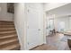 Bright hallway features a staircase, white door, and an open view into the kitchen and living area at 11569 Kimberly Way # 26, Hampton, GA 30228
