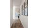Hallway with wood-look flooring, neutral paint, and a series of decorative framed art pieces at 11569 Kimberly Way # 26, Hampton, GA 30228