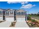 Modern townhome exterior with a two-car garage, complemented by fresh landscaping and a welcoming entrance at 11569 Kimberly Way # 26, Hampton, GA 30228