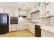 Functional kitchen with wood cabinets, black appliances, and a durable patterned floor at 1316 Sanders Dr, Morrow, GA 30260