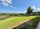 A sprawling backyard offers lush green space, framed by a black wooden fence, with scenic views and mature trees at 5515 Allegre Pl, Cumming, GA 30028