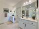 This bright bathroom features dual sinks, white cabinets, a walk-in shower, and neutral tile at 5515 Allegre Pl, Cumming, GA 30028