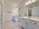 Elegant bathroom featuring a double vanity with white cabinets and a framed mirror at 5515 Allegre Pl, Cumming, GA 30028