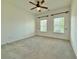 Bright bedroom with two windows, a ceiling fan, and neutral carpet at 5515 Allegre Pl, Cumming, GA 30028