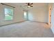 Bright and airy bedroom with plush carpeting, two windows, and a ceiling fan at 5515 Allegre Pl, Cumming, GA 30028