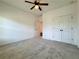 Spacious bedroom with neutral carpet, a ceiling fan, and a closet with double doors at 5515 Allegre Pl, Cumming, GA 30028