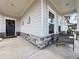 Welcoming front porch with a wreath on the door, a seating area, and stone accents on the pillars at 5515 Allegre Pl, Cumming, GA 30028
