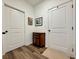 Hallway with wood-look floors, white doors, and decorative wall art at 5515 Allegre Pl, Cumming, GA 30028