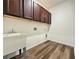 The laundry room features a utility sink, brown cabinets, and hook-ups for a washer and dryer at 5515 Allegre Pl, Cumming, GA 30028