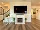 Bright living room featuring a fireplace with a mounted television and wood-look floors at 5515 Allegre Pl, Cumming, GA 30028