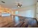 Spacious living room featuring wood-look flooring, a ceiling fan, and large windows at 5515 Allegre Pl, Cumming, GA 30028