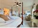 This main bedroom boasts a four-poster bed, ceiling fan and chair, creating a cozy and inviting space at 5515 Allegre Pl, Cumming, GA 30028