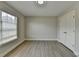 This bedroom features neutral walls, hard surface floors, large window, and a closet at 5976 Princeton Run Trl, Tucker, GA 30084