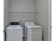 Bright laundry area featuring a washing machine and dryer, complete with overhead shelving at 5976 Princeton Run Trl, Tucker, GA 30084