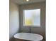 Bathroom featuring a standalone soaking tub and frosted window at 685 Egrets Lot 58 Lndg, Covington, GA 30014