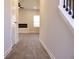 Hallway featuring hardwood flooring and an electric fireplace across from the staircase at 685 Egrets Lot 58 Lndg, Covington, GA 30014