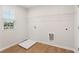 Clean laundry room with connections, shelving, wood-look flooring, and a window at 7099 Brushwood Bend (Lot 49), Lithonia, GA 30058