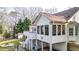 Rear view of the home featuring a deck and sunroom, with a fire pit, and a covered patio below at 1074 Fieldstone Dr, Canton, GA 30114