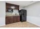 A basement kitchenette featuring dark cabinets, granite countertops, a microwave, and a refrigerator at 1074 Fieldstone Dr, Canton, GA 30114