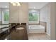 Bathroom featuring double sink, a soaking tub, decorative tiles, and a large window at 1074 Fieldstone Dr, Canton, GA 30114