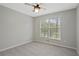 A simple bedroom with neutral walls and carpet, and a window with outside view at 1074 Fieldstone Dr, Canton, GA 30114