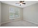 A bright bedroom featuring neutral walls, plush carpeting, and a window offering a view of the outdoors at 1074 Fieldstone Dr, Canton, GA 30114