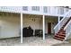 Covered patio with brick flooring, outdoor seating, grill, and stairs leading to the upper deck at 1074 Fieldstone Dr, Canton, GA 30114