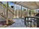 Cozy covered patio with stone pavers, stairs, outdoor seating, and views of the wooded backyard at 1074 Fieldstone Dr, Canton, GA 30114