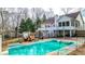 A turquoise swimming pool is surrounded by seating, a two-story deck, and mature trees at 1074 Fieldstone Dr, Canton, GA 30114
