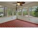A sunroom featuring a ceiling fan, a wooden floor, and multiple windows overlooking the surrounding greenery at 1074 Fieldstone Dr, Canton, GA 30114