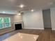 Bright living room with hardwood floors, fireplace, ceiling fan, and a large window showcasing the outdoor view at 2108 Amaryllis Dr, Grayson, GA 30017