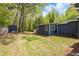 Sprawling backyard featuring a private shed, lush lawn, and mature trees, ideal for outdoor activities and storage at 2724 Bomar Rd, Douglasville, GA 30135