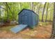 Private shed with double doors and a ramp for accessibility, nestled among trees in a serene setting at 2724 Bomar Rd, Douglasville, GA 30135