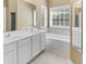 Bathroom featuring double sinks, a soaking tub, and a window for natural light, offering a relaxing space at 207 Cole Ct, Canton, GA 30114