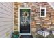 Close up of front door with stone veneer, decorative wreath, and charming chairs at 207 Cole Ct, Canton, GA 30114