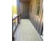 Cozy outdoor balcony with wood-like flooring and partial wooded view at 445 Firefly Cir # 40, Alpharetta, GA 30009