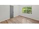 Bedroom featuring wood-style floors, neutral walls, and a large window at 5789 Star Flower Dr, Ellenwood, GA 30294
