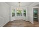 Elegant dining room with chair rail, modern chandelier, and large bay windows at 5789 Star Flower Dr, Ellenwood, GA 30294