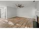 Open living room with wood flooring, a ceiling fan, and a fireplace at 5789 Star Flower Dr, Ellenwood, GA 30294