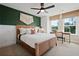 This bedroom has white walls with green accents, a large bed, and a small desk near a window at 114 Briargate Dr, Johns Creek, GA 30097