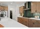 Modern kitchen featuring stainless steel appliances, island with white countertop, and green tile backsplash at 114 Briargate Dr, Johns Creek, GA 30097