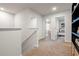 Upstairs hallway with neutral carpet and view into two of the bedrooms at 11567 Kimberly Way # 25, Hampton, GA 30228